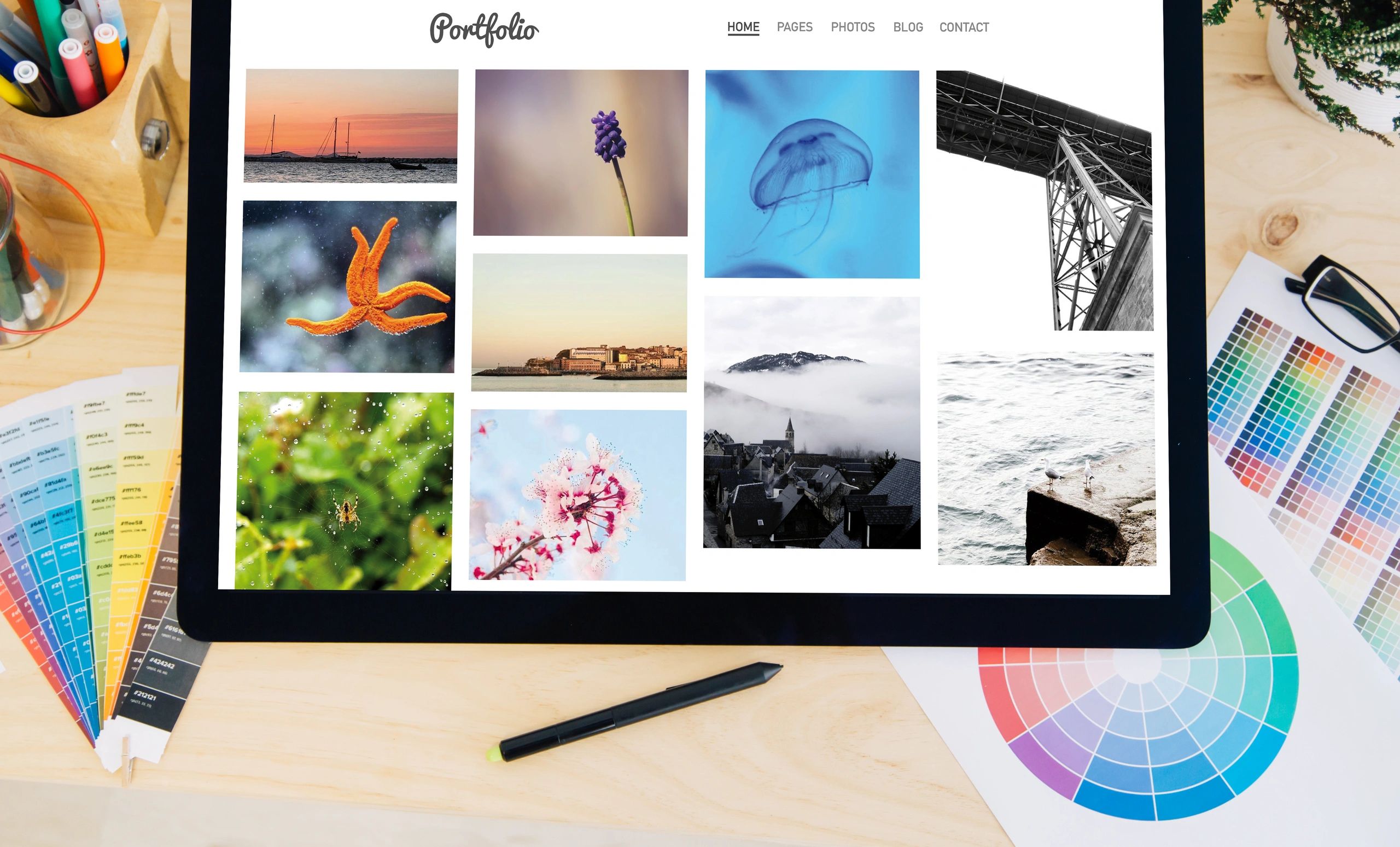 tablet pro touchscreen on desktop with creative photo portfolio on screen